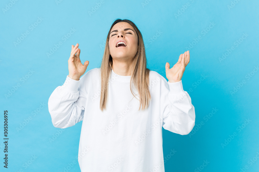 Young caucasian woman isolated screaming to the sky, looking up, frustrated. Young caucasian woman isolated screaming to the sky, looking up, frustrated.