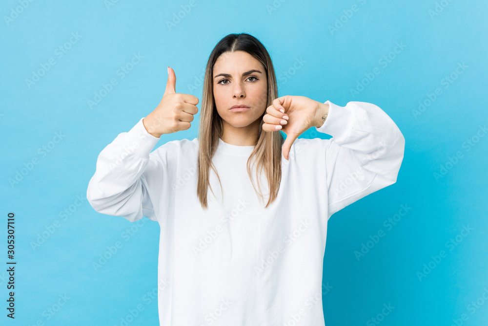 Young caucasian woman isolated showing thumbs up and thumbs down, difficult choose concept Young caucasian woman isolated showing thumbs up and thumbs down, difficult choose concept