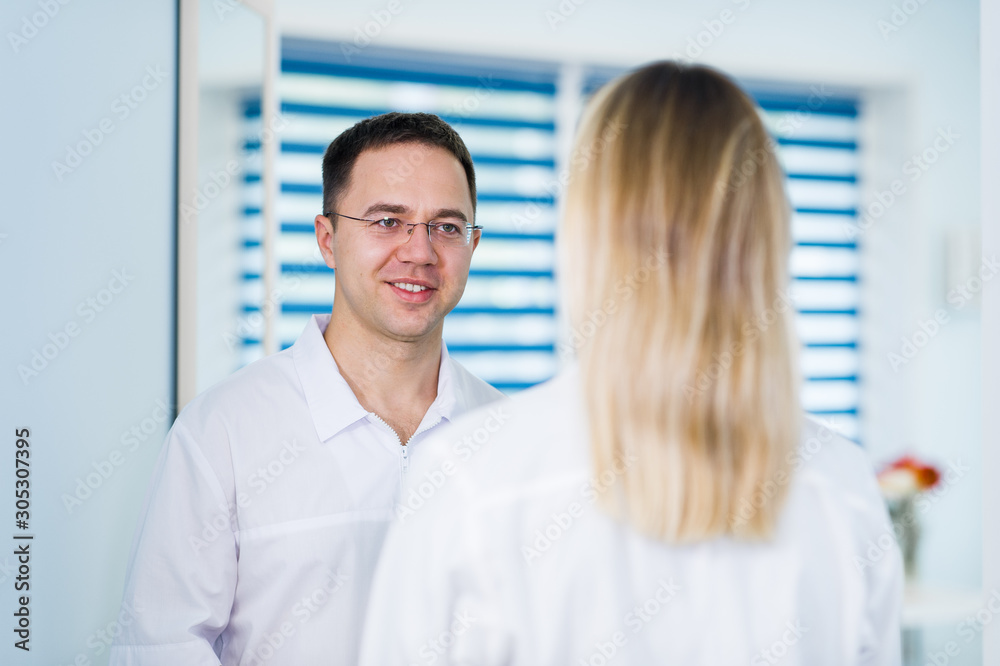 Doctor talking and laughing with his nurse assistant Doctor talking and laughing with his nurse assistant