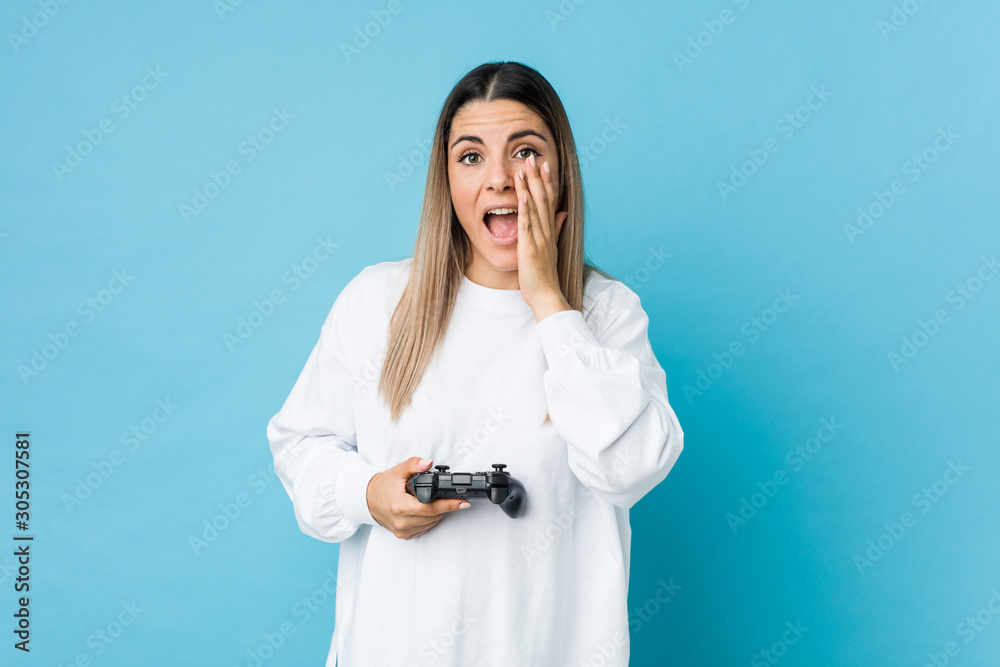 Young caucasian woman holding a game controller shouting excited to front. Young caucasian woman holding a game controller shouting excited to front.