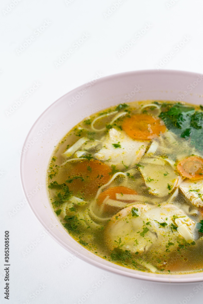 Classic chicken noodle soup with carrot and parsley isolated on white Classic chicken noodle soup with carrot and parsley isolated on white