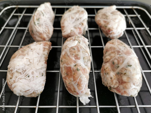 Traditional Cypriot food. Sheftalia : Cypriot Lamb and Pork Sausages. Raw sausages on a metal grill before baking. photo