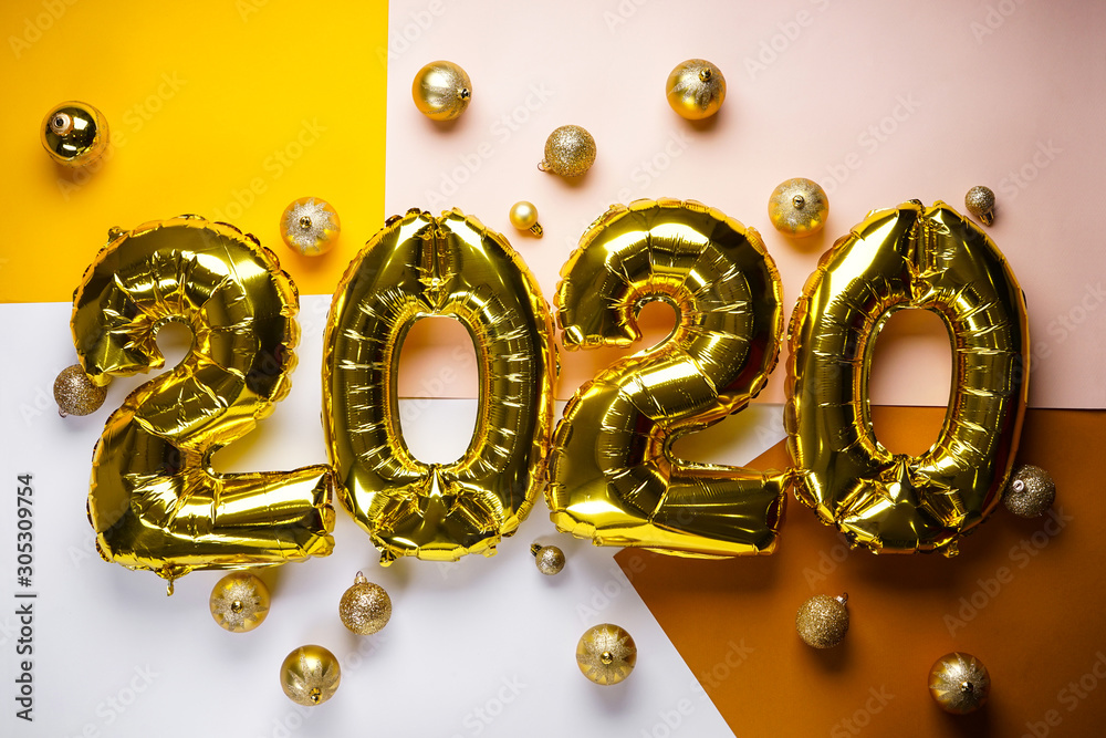 Celebrating the New Year 2020, golden foil balloons 2020 on colorful backgrounds, with golden toys. Foil balls. Celebrating the New Year 2020, golden foil balloons 2020 on colorful backgrounds, with golden toys. Foil balls.