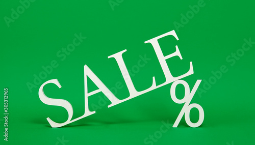 Green Friday concept. Wooden symbol with text Sale on green backround. Shape of percent