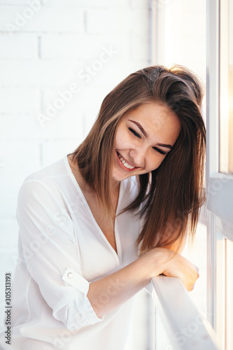girl is laughing next to the window