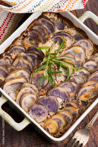 Violet potato gratin with cream and rosemary photo