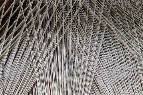 Close up of a lot of threads in a weaving machine called a loom photo