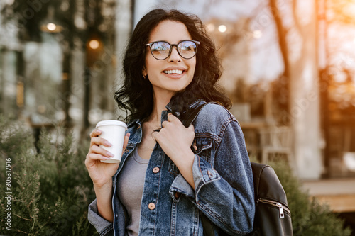 Cheerful coffee lover walking on street photo