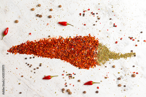 Fototapeta Naklejka Na Ścianę i Meble -  Chili pepper made of spices on light background