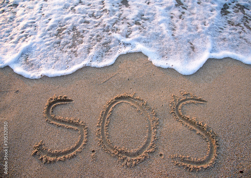 SOS - word drawn on the sand beach photo
