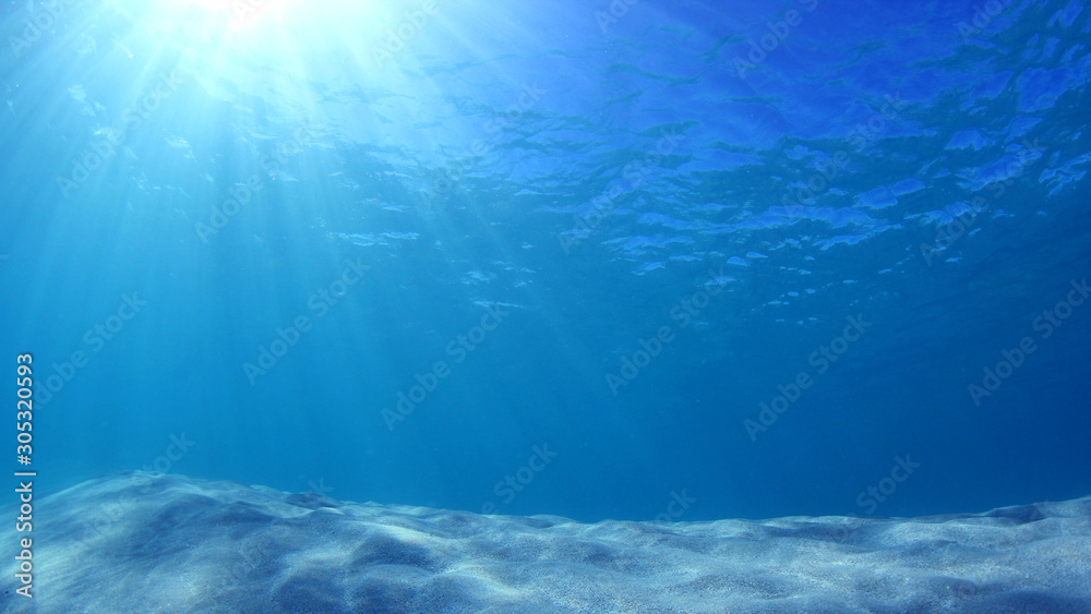 Underwater blue background in ocean with sunbeams Stock Photo