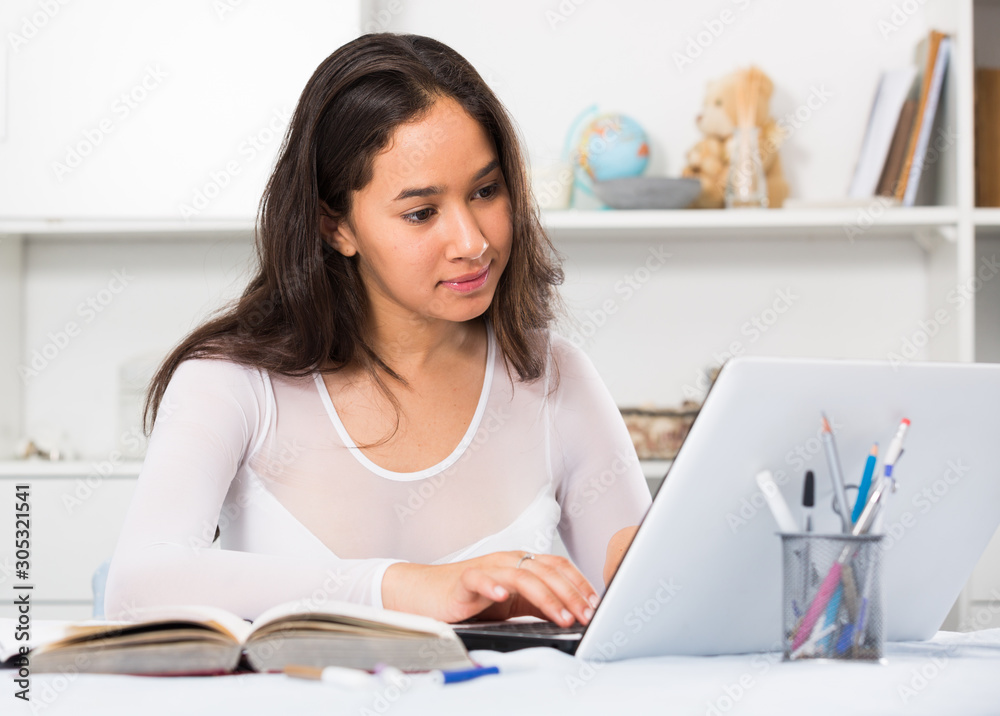 teenager female reading info in laptop