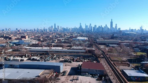 aerial drone landscape view of a urban neighborhood on the west side of Chicago during afternoon. skyscraper of tall buildings can be seen in the background. while the small communities are quite.  