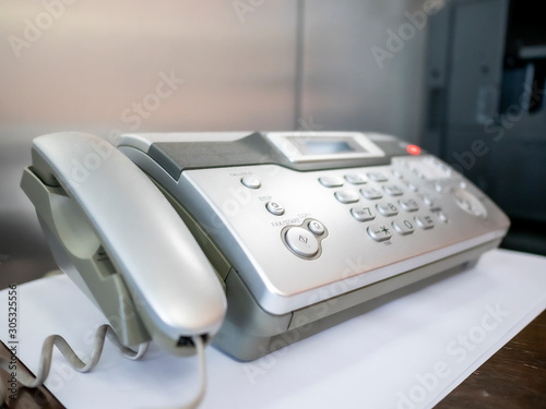 Telephone and fax machine on table in office