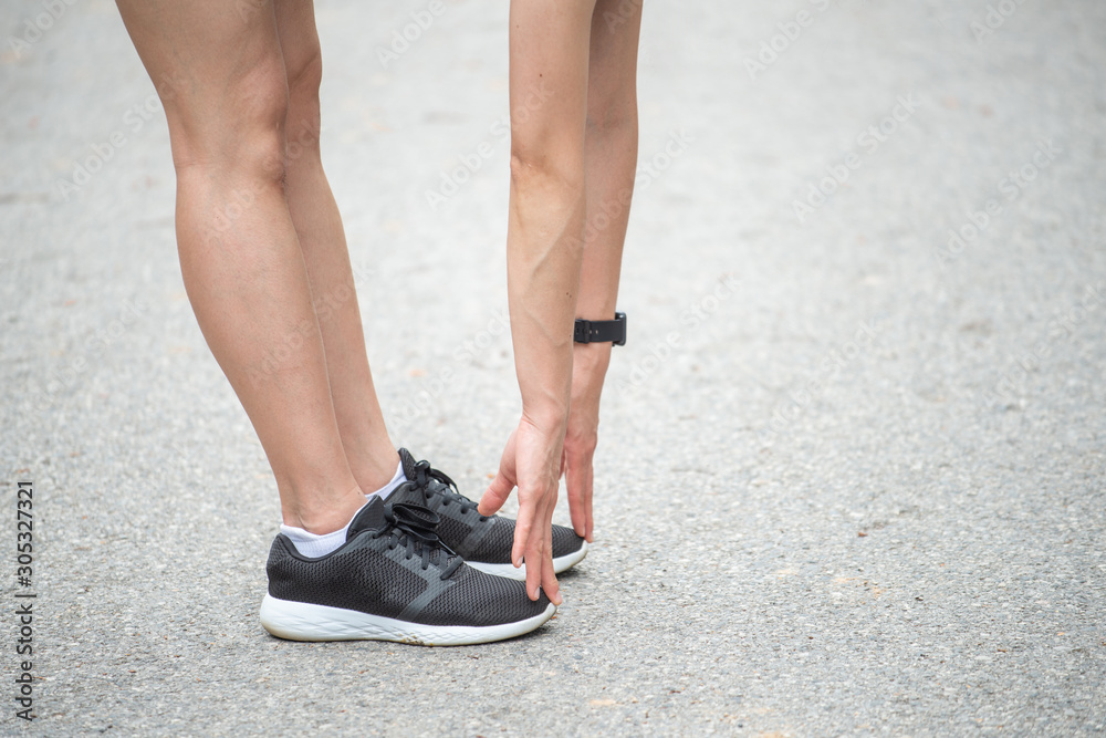 Cropped shot view of runner woman doing stretching and warming up her legs before running. The benifit of stretching can increasing flexibility performance and reduce risk of injury. 