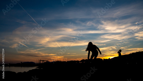 silhouetted people on the French Riviera beach at sunset in winter