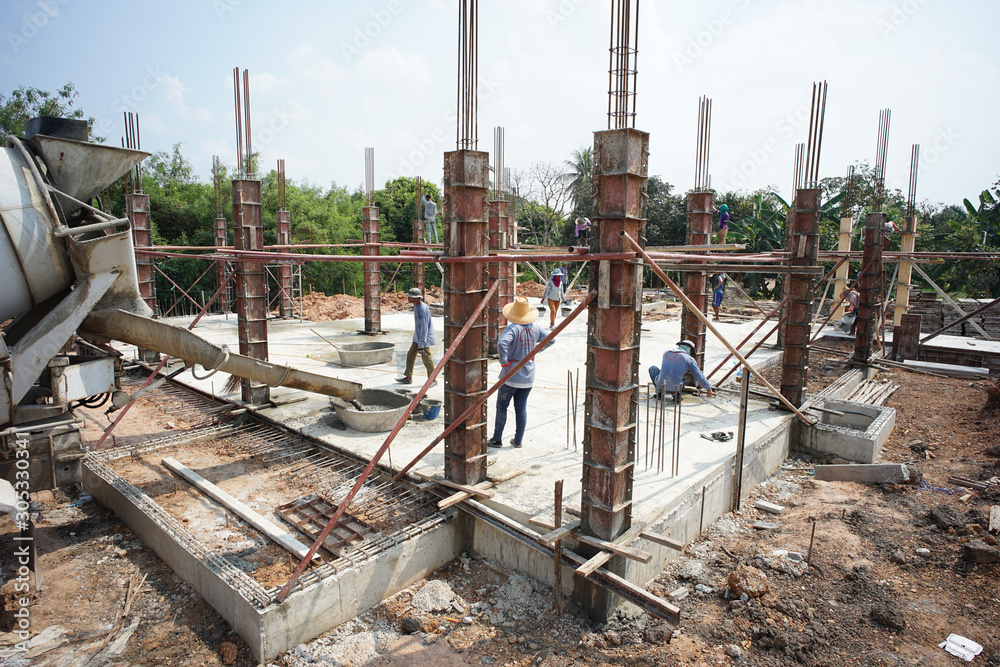 Ratchaburi, Thailand:March 1, 2018 - Group of worker build the foundation of house by pouring the mixed cement into the wooden model at the construction site