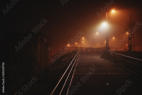 dramatic light on a bridge during a foggy night in Leipzig, Germany