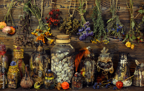 Fototapeta Witch laboratory with potion, elixirs, glass bottles, dry flowers, herbs and ingredients