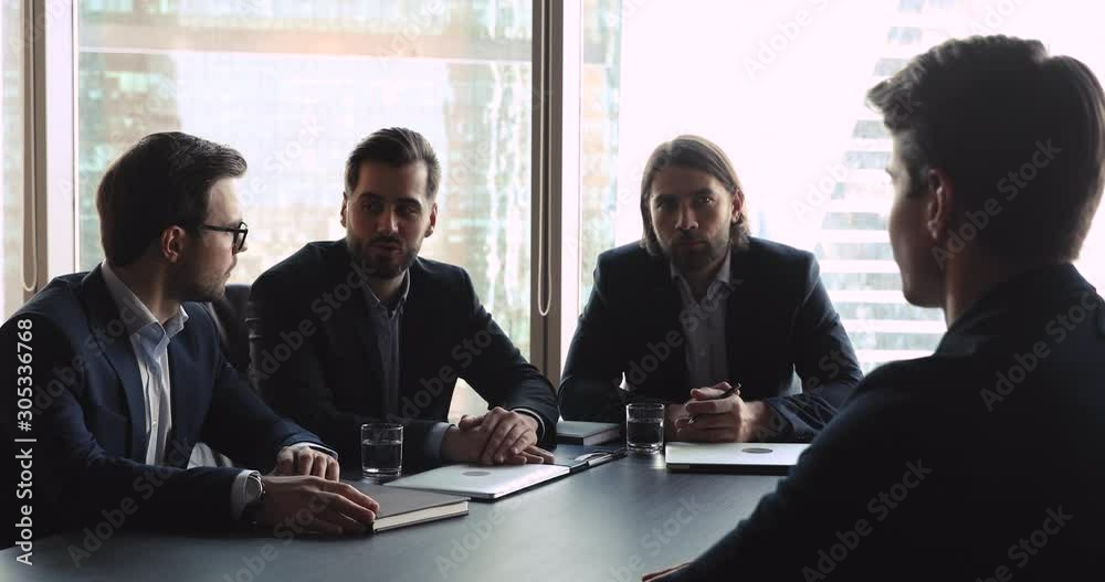 Company employers discussing work experience with male seeker at interview Company employers discussing work experience with male seeker at interview