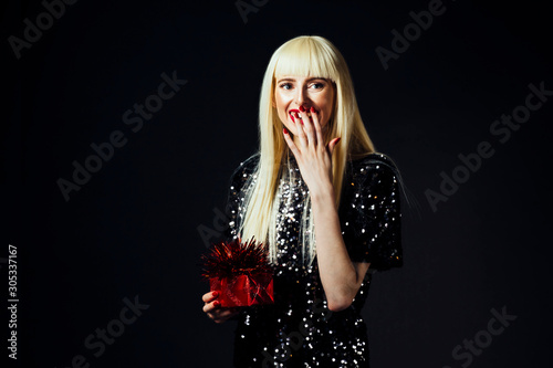 Portrait of a beautiful woman holding a gift isolated on black studio background