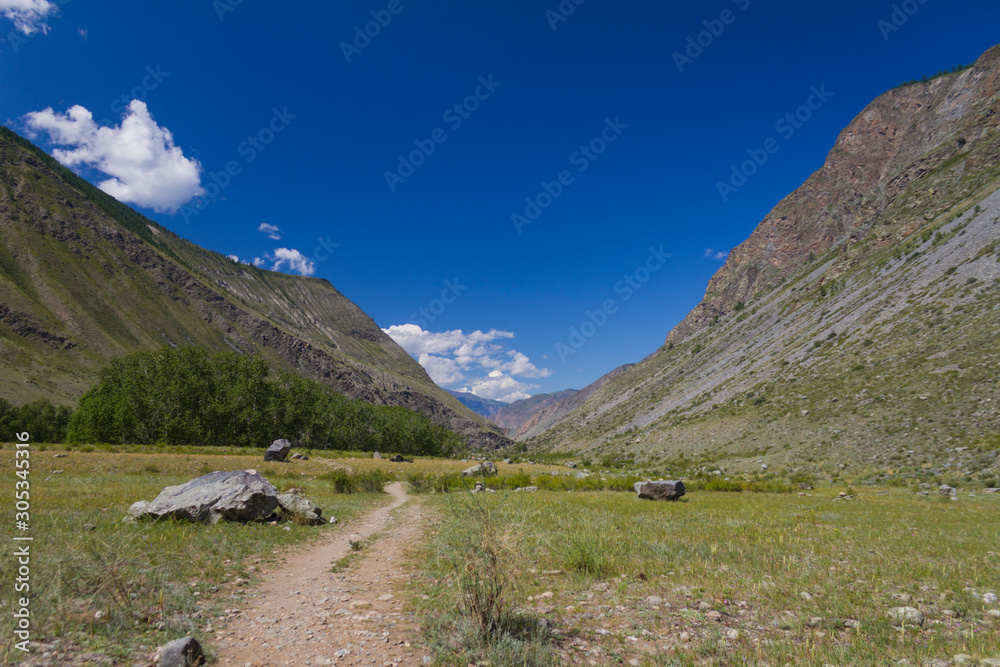 Panoramic view of Altay mountain valley with white clouds.
