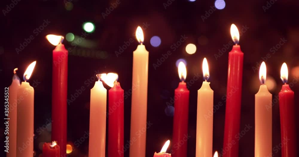 Red and white candles being blown out slowly in front of christmas decorations - slow motion - shot on RED Red and white candles being blown out slowly in front of christmas decorations - slow motion - shot on RED