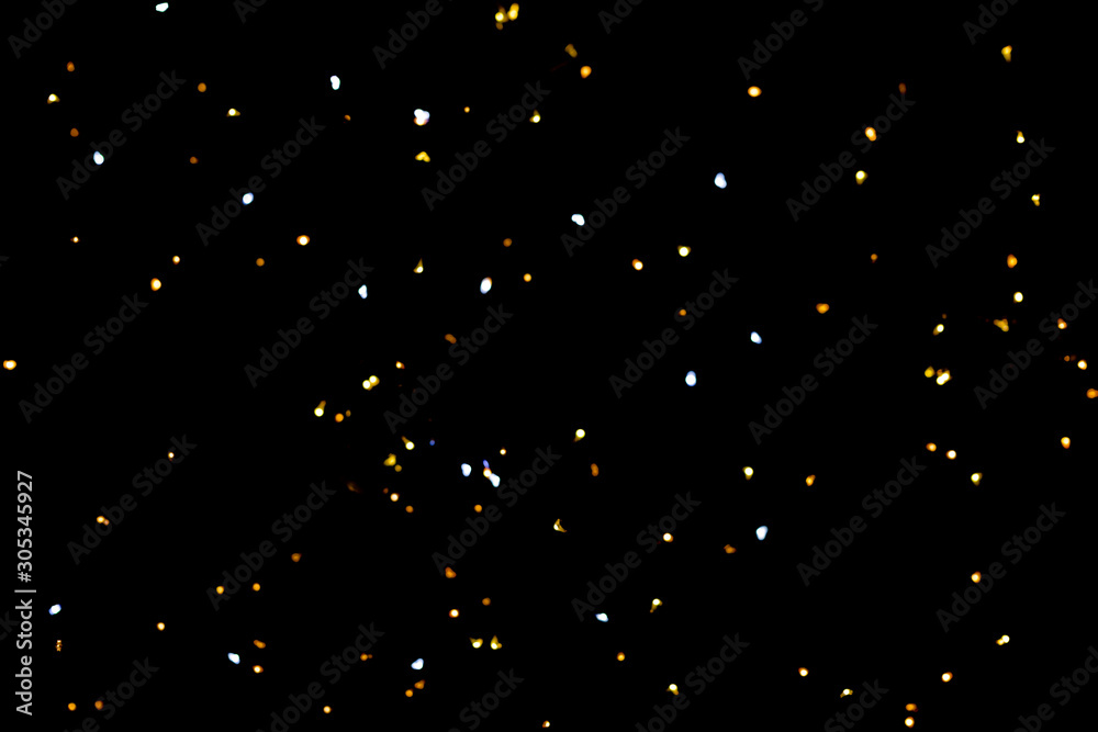Fototapeta premium Golden glitter bokeh lights on black background, unfocused. Holiday time.