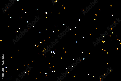 Golden glitter bokeh lights on black background, unfocused. Holiday time. © Anastassiya 