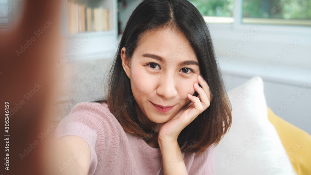 Young Asian teenager woman vlog at home, female using smartphone making vlog video to social media in living room. Lifestyle woman relax in morning at home concept. Young Asian teenager woman vlog at home, female using smartphone making vlog video to social media in living room. Lifestyle woman relax in morning at home concept.