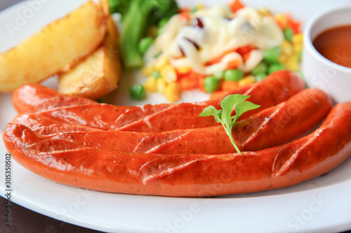 Grilled homemade sausage served with sauce and salad