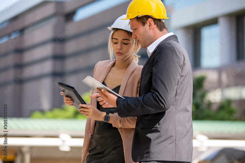Portrait of multiethnic architect or engineer man and women or business industrial man engineer look away while standing at construction building Portrait of multiethnic architect or engineer man and women or business industrial man engineer look away while standing at construction building