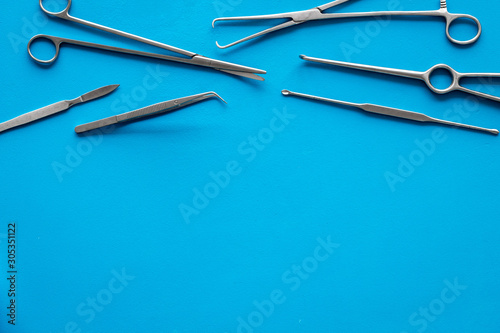 Plastic surgery. Instruments for beauty operations on blue background top view frame copy space