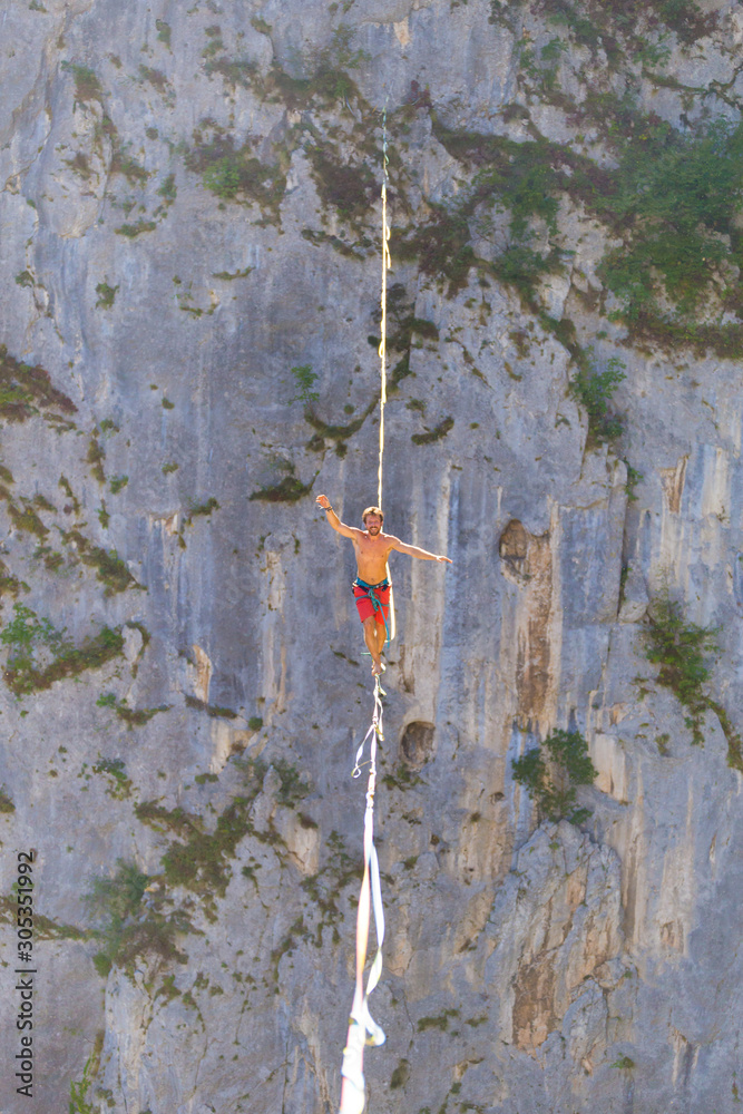 Naklejka premium A man walks confidently along the highline.