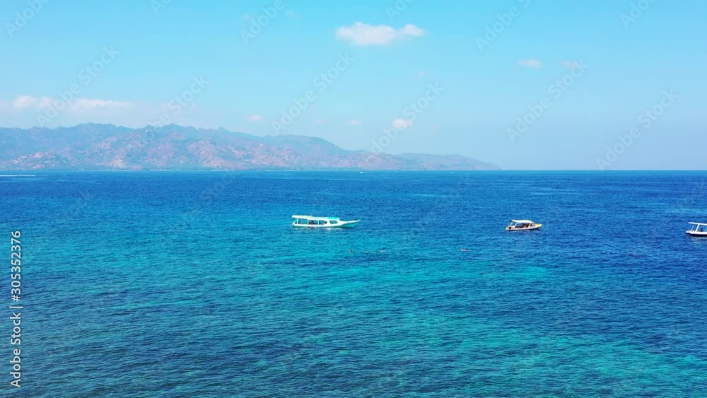 Tourist Boats Floating In The Open Sea Of The Pacific Ocean With Mountains, Sky And Clouds In The Background - Aerial Shot Tourist Boats Floating In The Open Sea Of The Pacific Ocean With Mountains, Sky And Clouds In The Background - Aerial Shot