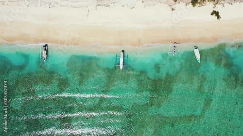 Philippine Island - Boats docked by the shoreline in the sandy beach on a sunny day - Aerial Shot  photo