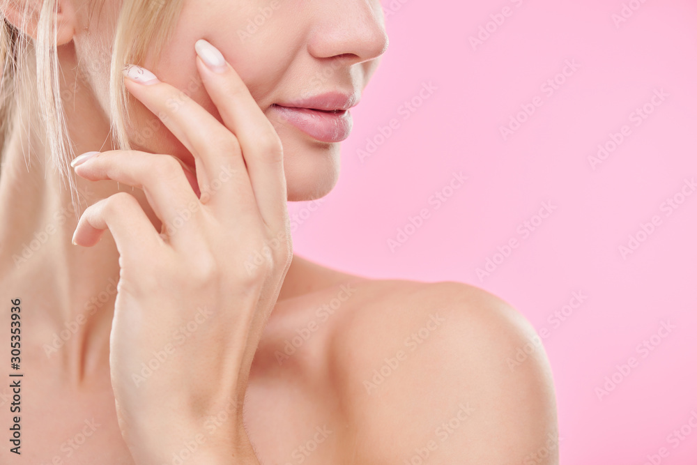 Hand of young healthy woman touching her face while taking care of skin Hand of young healthy woman touching her face while taking care of skin