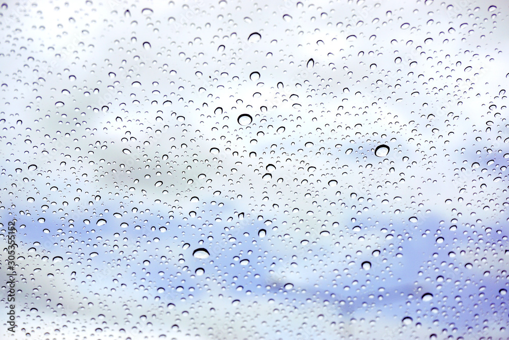 Raindrops on glass under the blue sky background. Raindrops on glass under the blue sky background.