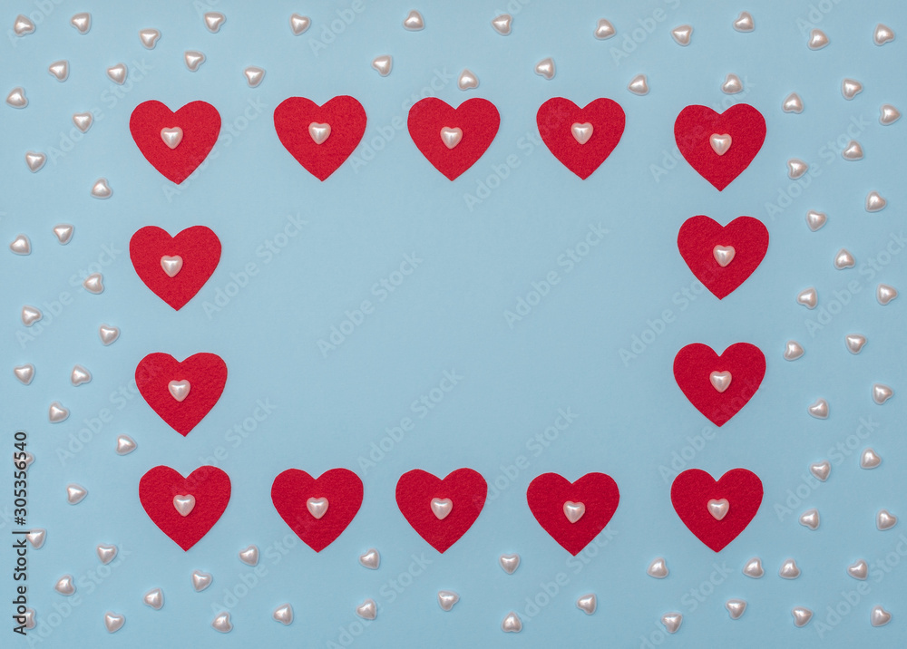 Valentine's Day blue background with red and pearl hearts. Valentine greeting card. Flat lay style. 