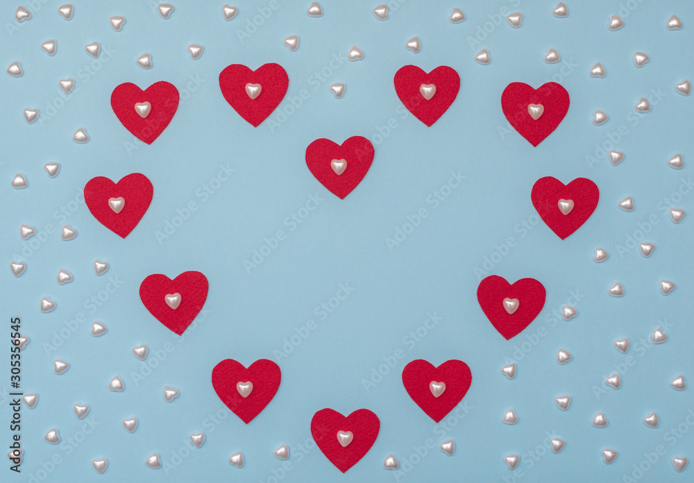 Valentine's Day blue background with red and pearl hearts. Valentine greeting card. Flat lay style. 