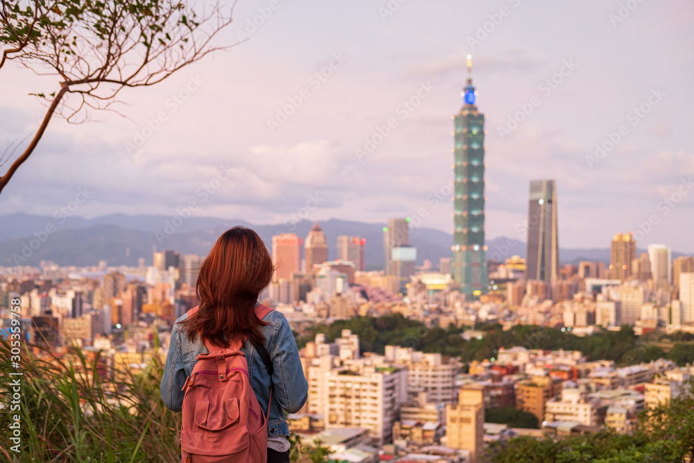 Fototapeta premium Young woman traveler looking beautiful cityscape at sunset in Taipei, Travel lifestyle concept