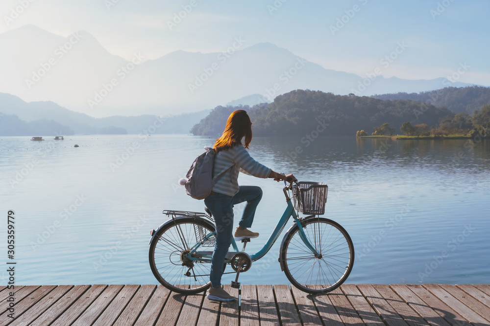 Young woman riding bicycle on Sun Moon lake bike trail, Travel lifestyle concept