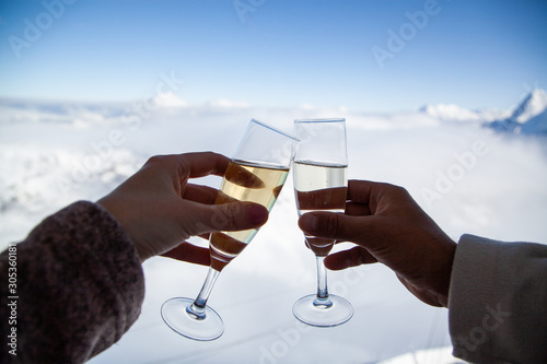 Photography couple drinking champagne and snowy mountains winter holiday