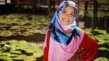 Portrait of young girl wearing traditional dress 'baju kurung' with hijab. Selected focus. Image contain certain grain or noise and soft focus when view at full resolution.