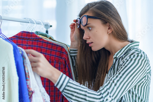 Quadro em tela Surprised shocked woman looking at high price tag on female expensive luxury clo