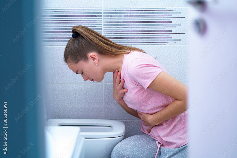 Young woman suffers from nausea and vomiting due to digestive and belly