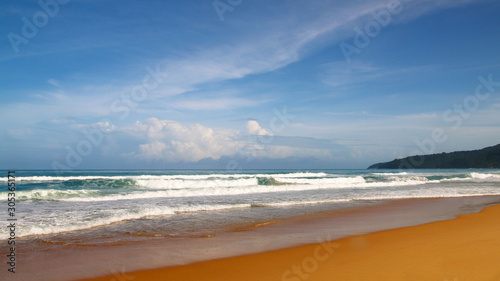 Waves, surf, and the blue sky over the sea, Karon sandy beach on a sunny day, Thailand
