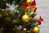 Beautiful green Christmas tree decorated with yellow balls, red bows and garlands. Close-up photo