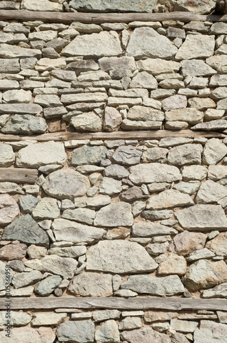 Old stone wall with three wooden beams