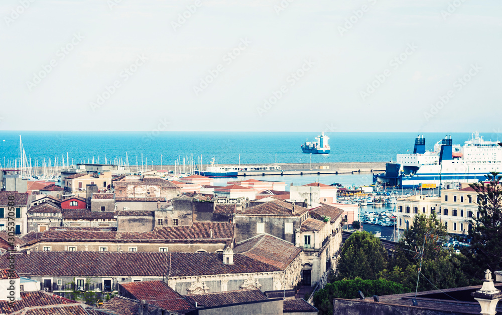 Catania rooftops with sea, port and boats view on background, aerial cityscape, traditional architecture of Sicily,  Southern Italy.